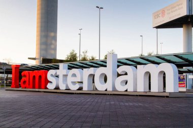 Kırmızı ve beyaz görünüm Ben Amsterdam işareti Schiphol havaalanı varış / çıkış güvertesi.