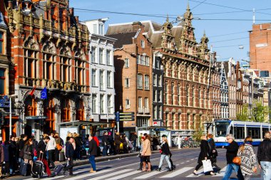 AMSTERDAM, NETHERLANDS - Kasım 08, 2014: Amsterdam ve eski binalardan birinin görüntüsü. Magna Plaza mağazasının yanındaki caddeden insanlar geçiyor..