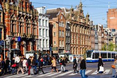 AMSTERDAM, NETHERLANDS - Kasım 08, 2014: Amsterdam ve eski binalardan birinin görüntüsü. Magna Plaza mağazasının yanındaki caddeden insanlar geçiyor..