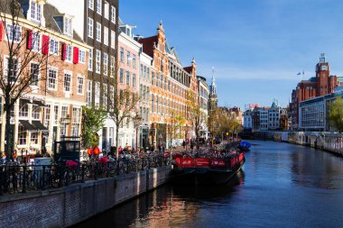 AMSTERDAM, NETHERLANDS - Kasım 08: Hollanda, 08 Kasım 2014 'te çiçek pazarı yakınında Amsterdam kanalları. Amsterdam 'daki kanallar ve limanlar şehir yüzeyinin dörtte birini dolduruyor..