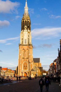 DELFT, NETHERLANDS - 10 Kasım 2014 'te insanlar Hollanda' nın Delft kentinde Yeni Kilise yakınlarında yürür. Yeni Kilise 1655 yılında tamamlandı ve 1584 yılından beri kraliyet mezarı olarak kullanılıyor..