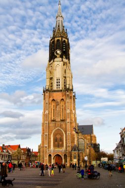 DELFT, NETHERLANDS - 10 Kasım 2014 'te insanlar Hollanda' nın Delft kentinde Yeni Kilise yakınlarında yürür. Yeni Kilise 1655 yılında tamamlandı ve 1584 yılından beri kraliyet mezarı olarak kullanılıyor..