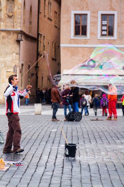 PRAGUE, CZECH REPUBLIC - 11 Kasım 2014: Çek Cumhuriyeti Prag 'da 11 Kasım 2014' te dev kabarcıklar çıkaran ve çocukları şaşırtan bir adam. Sokak Sanatı.