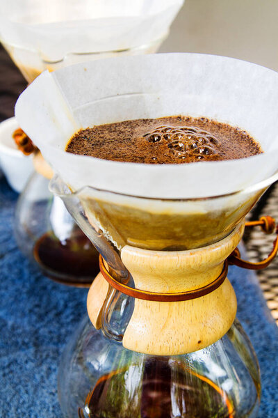 Кофе фильтруется на голубой поверхности
