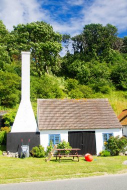 Tipik Bornholm mimarisi, tütsülenmiş bacası olan Bornholm ünlü yemeklerinden biri olan ringa balığı tüttürmek için kullanılır..