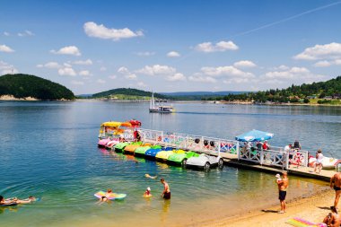 SOLINA, POLAND - 3 Haziran 2015 'te Polonya' nın Bieszczady dağlarındaki Solina Gölü 'ne bir pedallı veya kürek botu yanaştı..
