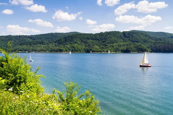 Solina Gölü 'ndeki yelkenli ve Polonya' daki Bieszczady dağlarındaki baraj.