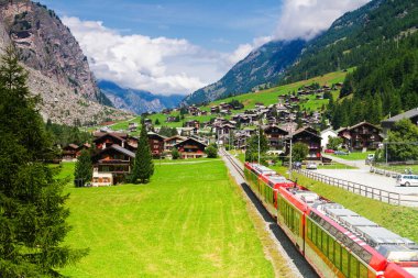 St. Moritz 'den Zermatt' a giden İsviçre 'deki yüksek dağlık vadiden geçen kırmızı tren..