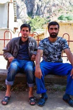 SARYTAG, TAJIKISTAN - 2 Ağustos 2015: Erkekler Fan Dağları 'ndaki basit bir mağazanın önündeki bankta oturuyorlar. Orta Asya