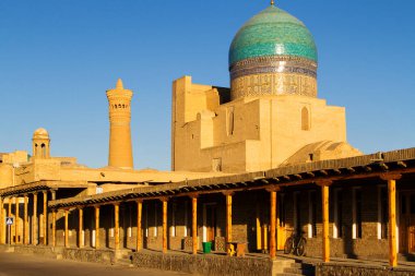 Özbekistan 'ın Buhara kentinde gün batımında UNESCO kompleksi Poi Kolon' un panoramik görüntüsü. Orta Asya. İpek Yolu 'nda yer alan şehir uzun zamandır ticaret, burs, kültür ve dinin merkeziydi..