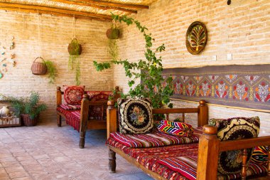 Eski Karavan Sarayı 'ndaki teras, geleneksel tarzda yapılmış ipek halılarla süslenmiş. Buhara, Özbekistan, Orta Asya. Buhara antik ipek yoldaki şehirlerden biridir..