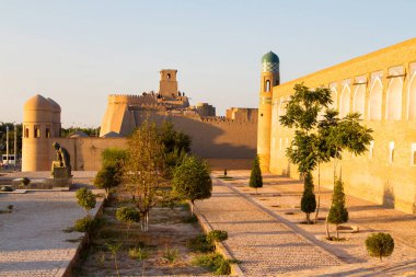 KHIVA, UZBEKISTAN - 15 Ağustos 2015: Batı kapısı (Ata Darvoza) antik Itchan Kala kasabasına. Orta Asya. Ebu Abdullah Muhammed 'in anıtı sol tarafta Musa el-Harezmi' nin anıtı..