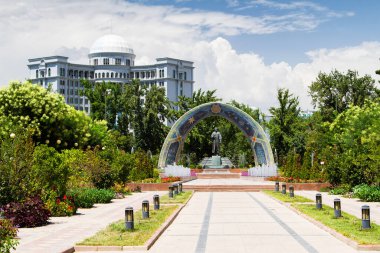 Dushanbe, Tacikistan, ve Tacik Pers şairi Ebu Abdullah Rudaki Cafer 'in bir anıtı, şehir merkezinde, çiçekler, mozaik kemer. Arka planda Foreing Affairs binası