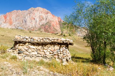 Yalnız kayalık, çoban kulübesi. Fan Dağları 'ndaki tepe ve dağ manzarası. Pamir. Tacikistan. Orta Asya. İskander Kul Yolu.