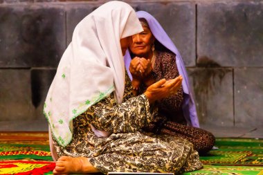 SAMARKAND, UZBEKISTAN - 10 Ağustos 2015 'te Özbekistan' ın Semerkant kentindeki birçok medreseden birinde kadınlar mozolede dua ediyor.