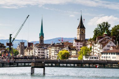 ZURİH, SWitzERLAND - 25 Ağustos 2014 'te İsviçre' nin Zürih kentindeki Limmat Nehri ve ünlü Zürih kiliselerinin manzarası. Zürih İsviçre 'nin en büyük şehri ve ana ekonomik merkezidir..