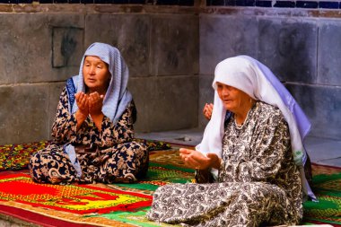 SAMARKAND, UZBEKISTAN - 10 Ağustos 2015 'te Özbekistan' ın Semerkant kentindeki birçok medreseden birinde kadınlar mozolede dua ediyor.