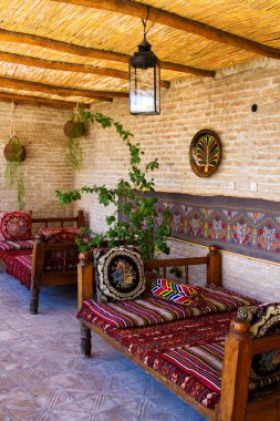 BÜKHARA, UZBEKISTAN - 29 Ağustos 2015: Eski Karavan Sarayı 'ndaki teras geleneksel tarzda yapılmış ipek halılarla süslenmiştir. Buhara, Özbekistan, Buhara antik ipek bir yol üzerindedir.