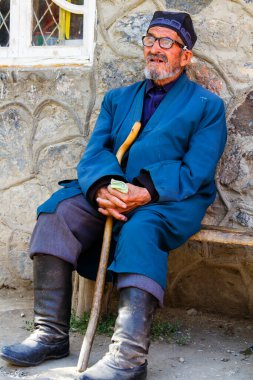 SARYTAG, TAJIKISTAN - 2 Ağustos 2015: Fan Dağları 'ndaki Tacik kırsalındaki basit bir mağazanın önündeki bankta oturan yaşlı bir adam. Tacikistan, Orta Asya.