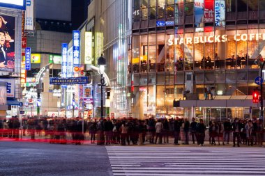 TOKYO, JAPONYA - 11 Kasım 2015: Shibuya 'nın seferleri meşhurdur. Yayaların tüm kavşağı istila etmesini sağlamak için tüm yönlerdeki araçları durdurur..