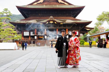 NAGANO, JAPONYA - 17 Kasım 2015 tarihinde Japonya 'nın Nagano kentindeki Zenkoji Tapınağı önünde Japon gelin. Tanımlanamayan damat ve gelin düğün töreni için geleneksel kıyafetler giyiyorlar.