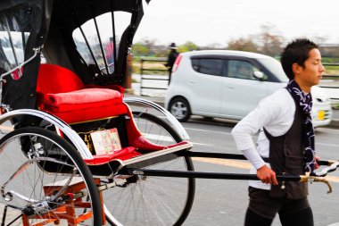 KYOTO, JAPONYA - 24 Kasım 2015 tarihinde Japonya 'nın Kyoto parkında çekilen triportörler. Erkekler tarafından çekilen Ricskshawlar turistler tarafından eski Kyoto 'yu (Gion) gezmenin popüler bir yoludur..