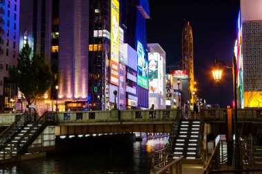 OSAKA, JAPONAN - 23 Kasım 2015: Japonya 'nın Osaka kentindeki Namba ilçesinde gece Dotonbori Kanalı' nın kıyısındaki parlak işaretler.