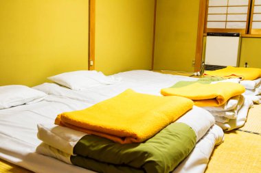 Otelde geleneksel Japon tarzı yatak odası. Otel çalışanları battaniye ve yatak örtüsü hazırlar, adı 