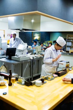 TOKYO - 17 Kasım 2015 'te Japon şef Tokyo' da bir restoranda suşi hazırlıyor. Suşi Japon yemeklerinin dünyaca ünlü mücevheridir..