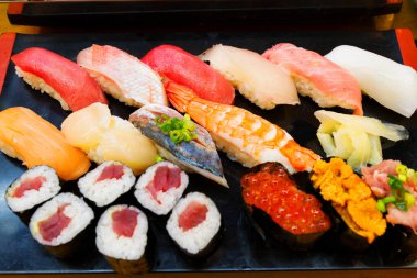 Suşi set nigiri ve suşi ruloları ahşap tahtada servis edilir.