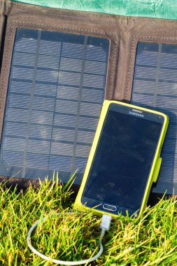 Dağ kampında katlanabilir güneş paneli şarj edilebilir cep telefonu