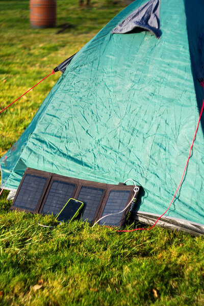 Foldable solar panel charges mobile phone on mountain base camp