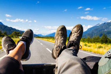 Otostopçular, Şili Carretera Austral 'da manzaralı ve güzel bir yolda bir pikapın arkasında gidiyorlar. Patagonya, Şili