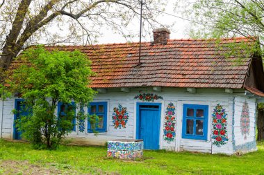ZALIPIE - 30 Nisan 2016: Polonya 'nın Zalipie köyündeki geleneksel renkli bir binanın cephesi. Zalipie, Polonya 'nın güneyinde çiçek motifli boyalı evlerle ünlü çok küçük bir köydür.