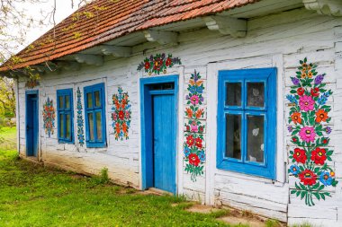 ZALIPIE - 30 Nisan 2016: Polonya 'nın Zalipie köyündeki geleneksel renkli bir binanın cephesi. Zalipie, Polonya 'nın güneyinde çiçek motifli boyalı evlerle ünlü çok küçük bir köydür.
