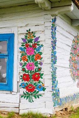 ZALIPIE - 30 Nisan 2016: Polonya 'nın Zalipie köyündeki geleneksel renkli bir binanın cephesi. Zalipie, Polonya 'nın güneyinde çiçek motifli boyalı evlerle ünlü çok küçük bir köydür.