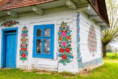 ZALIPIE - 30 Nisan 2016: Polonya 'nın Zalipie köyündeki geleneksel renkli bir binanın cephesi. Zalipie, Polonya 'nın güneyinde çiçek motifli boyalı evlerle ünlü çok küçük bir köydür.