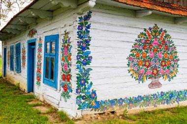 ZALIPIE - 30 Nisan 2016: Polonya 'nın Zalipie köyündeki geleneksel renkli bir binanın cephesi. Zalipie, Polonya 'nın güneyinde çiçek motifli boyalı evlerle ünlü çok küçük bir köydür.