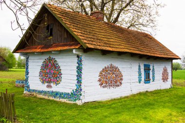 ZALIPIE - 30 Nisan 2016: Polonya 'nın Zalipie köyündeki geleneksel renkli bir binanın cephesi. Zalipie, Polonya 'nın güneyinde çiçek motifli boyalı evlerle ünlü çok küçük bir köydür.