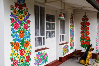 ZALIPIE - 30 Nisan 2016: Polonya 'nın Zalipie köyündeki geleneksel renkli bir binanın cephesi. Zalipie, Polonya 'nın güneyinde çiçek motifli boyalı evlerle ünlü çok küçük bir köydür.