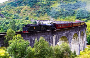 GLENFINNAN, SCOTLAND - 20 Ağustos 2016: Glenfinnan Demiryolu Viaduct İskoçya 'da Jakobit buharlı treni İngiltere' den geçiyor