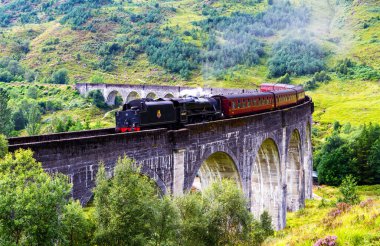 GLENFINNAN, SCOTLAND - 20 Ağustos 2016: Glenfinnan Demiryolu Viaduct İskoçya 'da Jakobit buharlı treni İngiltere' den geçiyor