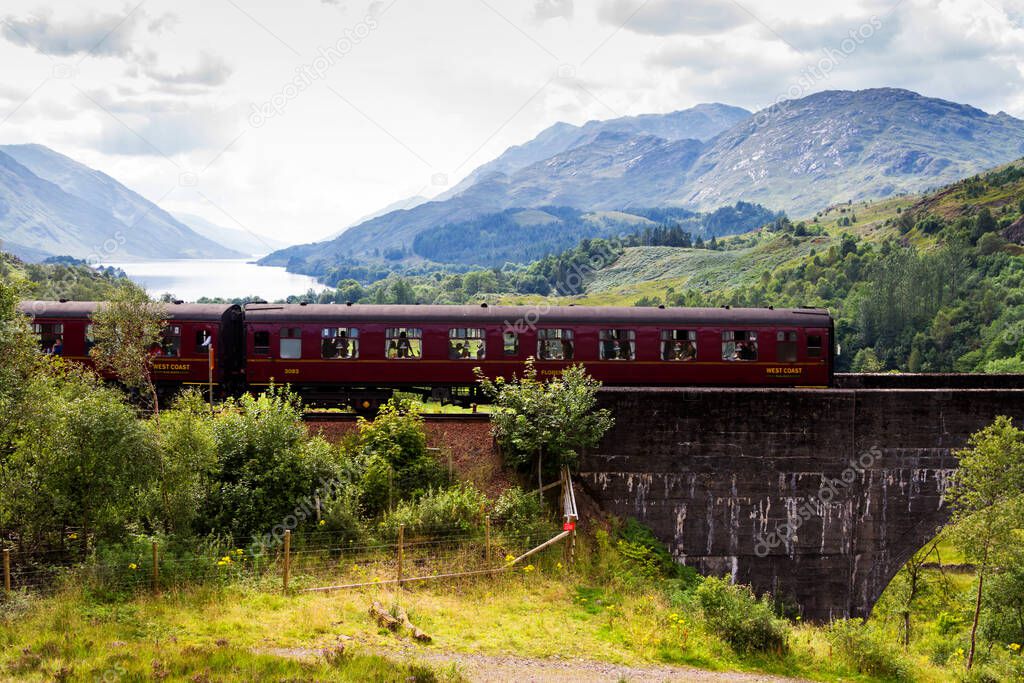 GLENFINNAN, SCOTLAND - AUGUST 20, 2016: Glenfinnan Railway Viaduct in Scotland with the Jacobite steam train passing over in United Kingdom