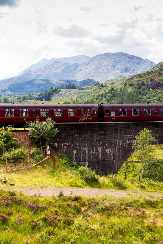 GLENFINNAN, SCOTLAND - AUGUST 20, 2016: Glenfinnan Railway Viaduct in Scotland with the Jacobite steam train passing over in United Kingdom