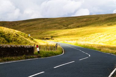 İngiltere 'nin kuzeyinde Yorkshire Dales Ulusal Parkı' ndaki dağlara giden yol manzarası. Yorkshire Dales, İngiltere 'nin kuzeyindeki bir dağ sırasıdır. Avrupa
