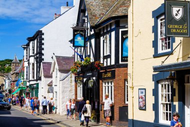 CONWY, WALES - 29 Ağustos 2016: Büyük Britanya 'nın Conwy, Galler' deki en küçük evinin rıhtımında ve dışında yaşayan turistler. Kasaba, 13. yüzyıl şatosu da dahil olmak üzere popüler bir turizm merkezidir..