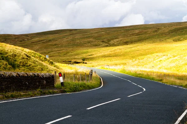 Road view to mountains in Yorkshire Dales National Park in North England of the United Kingdom. Yorkshire Dales is a mountain range and a region in North of England. Europe