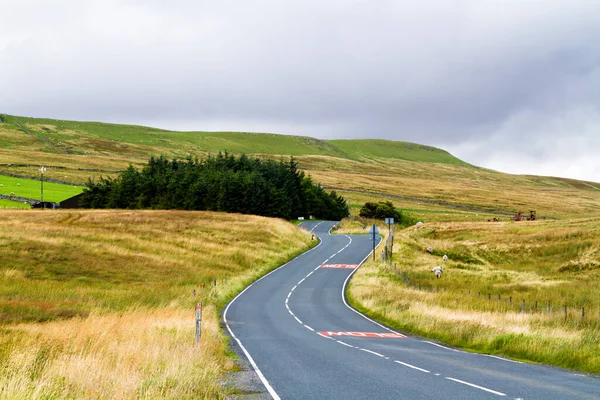 Road view to mountains in Yorkshire Dales National Park in North England of the United Kingdom. Yorkshire Dales is a mountain range and a region in North of England. Europe
