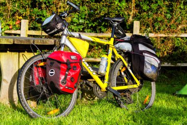 ABERYSTWYTH, WALES - 10 AĞUSTOS 2016: Yabancı bir gezi sırasında Wels kırsalında çimlerin üzerinde park etmiş panniers ile bisiklet.