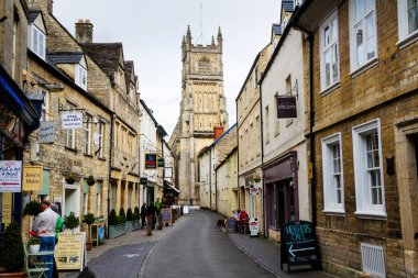 CRENCESTER, İngiltere - 5 Eylül 2016: Cirencester, İngiltere 'deki eski cadde. Restoranları ve kitapçıları olan kiliseye giden yol..